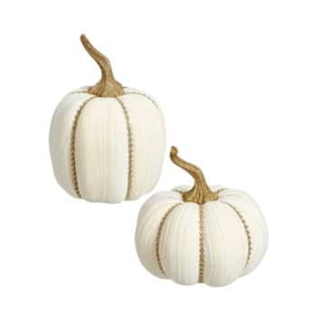 Two decorative white pumpkins with gold glittery stems on a white background. They feature ribbed textures and are positioned at different angles.