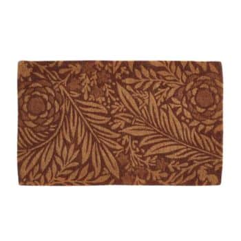 A rectangular coir doormat with a decorative pattern of flowers and leaves in brown and tan tones. The intricate design features large floral motifs surrounded by detailed leafy branches.