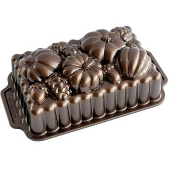 Bronze-colored loaf pan with detailed pumpkin and gourd shapes on the top, perfect for crafting fall-themed baked goods that beautifully complement your favorite fall dessert recipes.