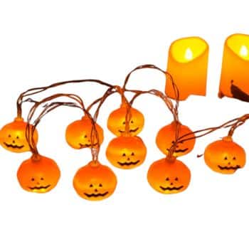 String lights with small, glowing pumpkin faces and two lit orange candles are displayed. The pumpkins, reminiscent of easy pumpkin crafts, are evenly spaced, each with a smiling Jack-o'-lantern design, creating a festive Halloween atmosphere.