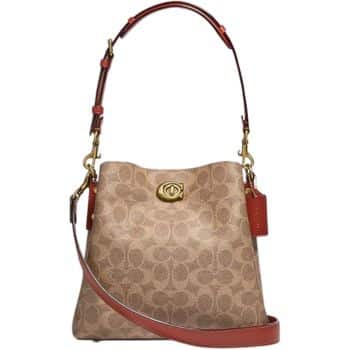 A beige handbag with a brown leather strap features a signature patterned design. It has a gold turn-lock closure and a small red tag attached to the handle.