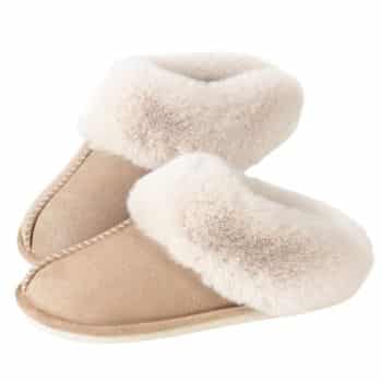 A pair of beige suede slippers with fluffy cream-colored lining, positioned side by side on a white background.