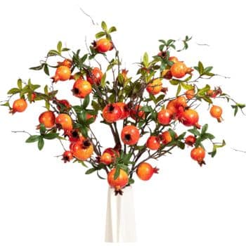 A decorative arrangement of vibrant red-orange pomegranate branches with green leaves in a white vase. The image highlights the clusters of fruit, emphasizing a lush and abundant appearance.