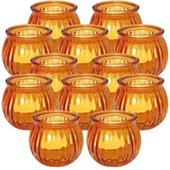 A collection of 12 amber glass candle holders, arranged in a tight grid pattern. Each holder has a round, ribbed design and a warm, glowing appearance.