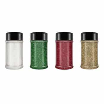 Four jars of glitter stand in a row, perfect for holiday craft ideas. From left to right, the shimmering colors are white, green, red, and gold. Each jar is topped with a sleek black cap.