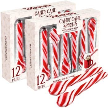 Two boxes of candy cane spoons with peppermint flavor. Each box contains 12 striped red and white spoons. A small mug is shown beside some spoons outside the box. Packaging reads "Candy Cane Spoons" and "12 pieces.