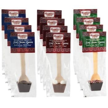 Six individually packaged hot cocoa spoons are displayed, with flavors including Belgian dark chocolate, dark chocolate peppermint, and milk chocolate peppermint. Each spoon stands in its own clear packaging with decorative labels.