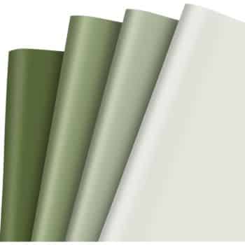 Four sheets of paper in varying shades of green are displayed, ranging from dark to light. They are aligned vertically and slightly overlapped, showcasing a gradient effect from the darkest on the left to the lightest on the right.