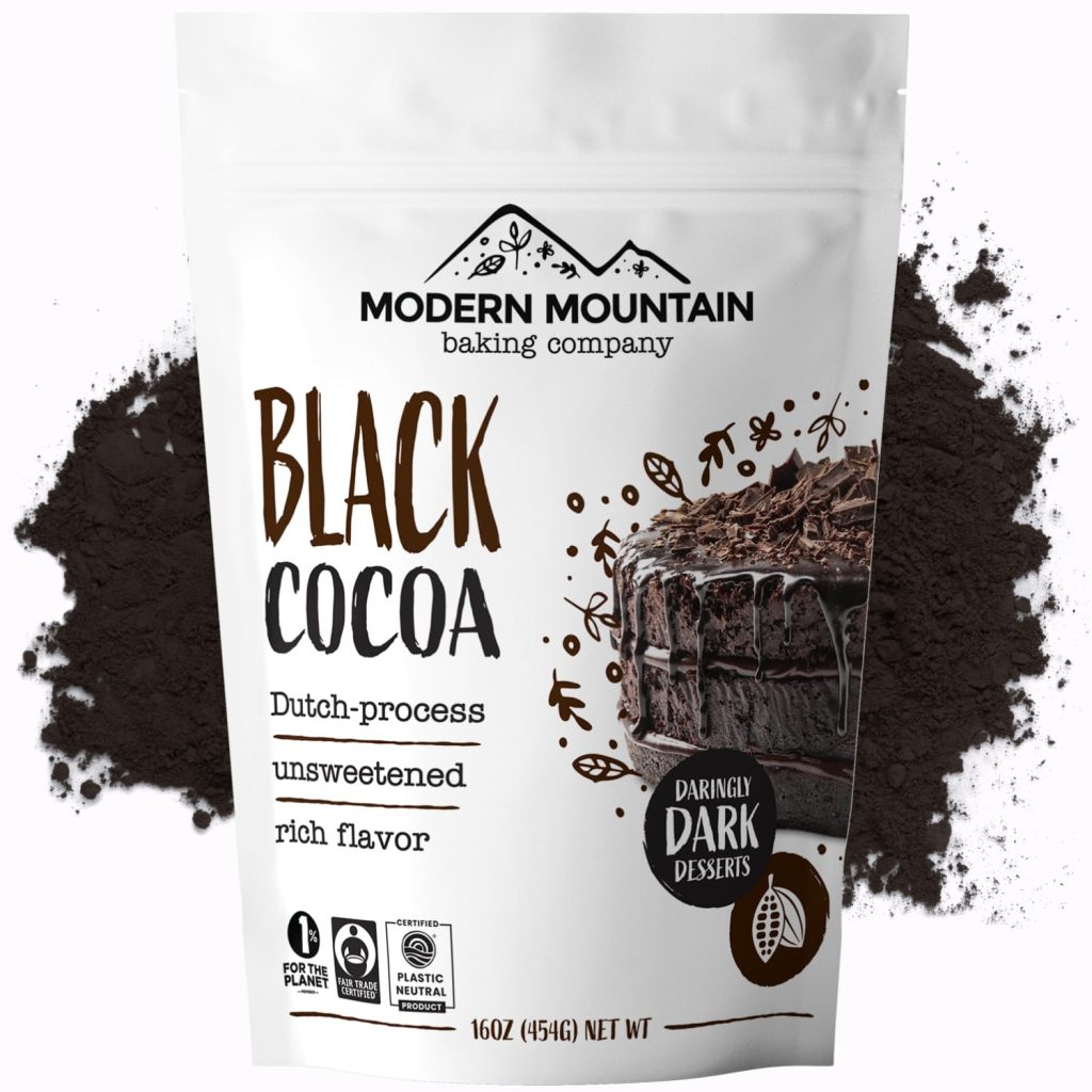 A 16oz bag of Modern Mountain Baking Company Black Cocoa is perfect for holiday baking. The white packaging, adorned with a chocolate cake image, suggests its rich flavor. Picture festive Christmas Tree Cookies crafted with this Dutch-process, unsweetened cocoa against a backdrop of cocoa powder.