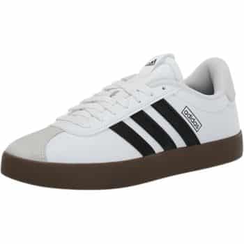 A white sneaker with black stripes, a brown sole, and a gray toe cap. The shoe features a white Adidas logo on the side and tongue.