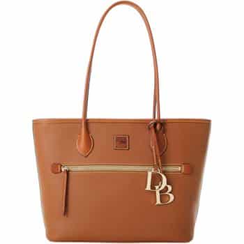 A brown leather tote bag with long handles, featuring a front zip pocket and decorative gold-tone initials "DB" attached to one handle. The bag has a smooth texture and stitching details.