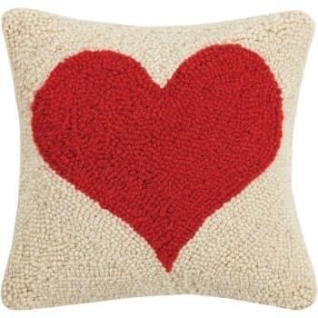 Square pillow with a textured design featuring a large red heart in the center, set against a cream woven background.