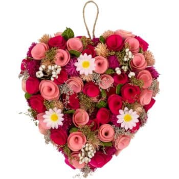 A heart-shaped floral arrangement featuring pink and red roses, white daisies, and small decorative white accents, all tied with a rustic string for hanging.