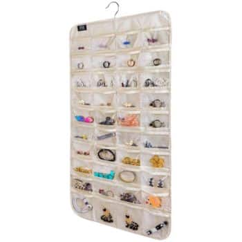 A beige hanging jewelry organizer with multiple transparent pockets, each containing various pieces of jewelry such as earrings, necklaces, and bracelets. It has a metal hanger for easy storage.