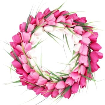 A circular arrangement of pink and white tulip petals intertwined with green leaves, forming a wreath on a white background.