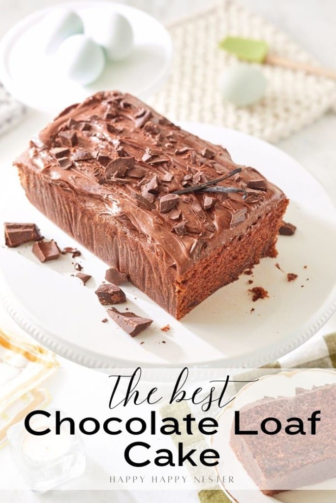 A chocolate loaf cake with rich frosting and chocolate shavings on top, placed on a white plate. The text overlay reads, "The best Chocolate Loaf Cake Recipe." Two eggs and kitchen props are in the background.