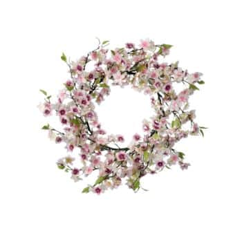 A floral wreath with pink and white flowers and green leaves arranged in a circular pattern against a plain white background.