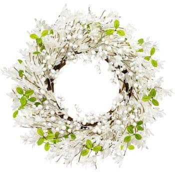 A wreath made of white flowers and white berries, interspersed with small green leaves, is arranged in a circular pattern. The design is airy and delicate, with a fresh and natural appearance against a white background.