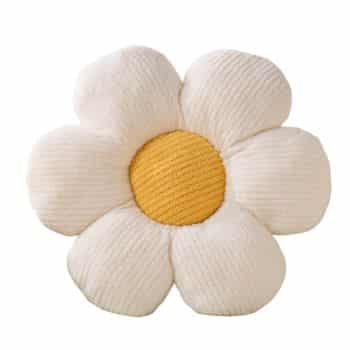 Plush pillow shaped like a daisy flower with creamy white petals and a textured yellow center, resembling a soft, oversized toy.