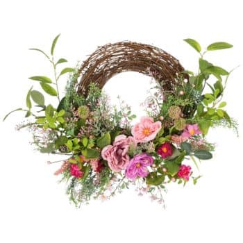 A wreath of intertwined brown branches adorned with vibrant pink, purple, and red flowers, surrounded by lush green leaves and sprigs. The flowers add a burst of color to the natural wood texture.