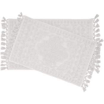 Two overlapping white fringed rugs with an intricate pattern. The rugs have tassels along the shorter edges, creating a decorative border. They are displayed on a plain background.