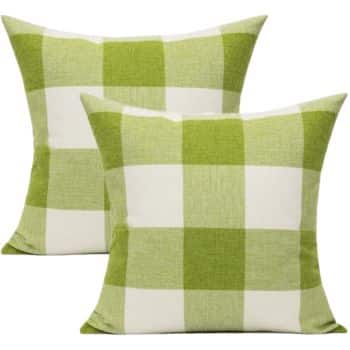 Two square throw pillows featuring a green and white checkered pattern. The design alternates between green and white squares, creating a classic plaid look. The pillows are set against a plain background.