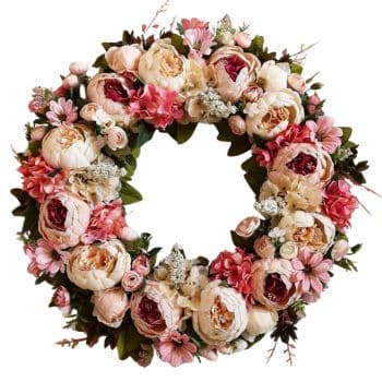 A decorative wreath composed of assorted pink and white flowers, including roses and peonies, with green leaves interspersed throughout. The arrangement forms a circular, floral design.