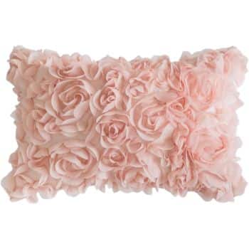 A rectangular pillow covered in pink fabric roses, giving it a soft, textured appearance.