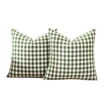 Two square pillows featuring a green and white gingham pattern are placed side by side against a plain white background.