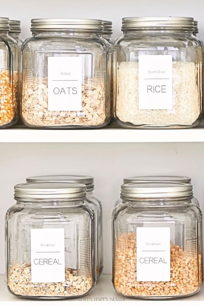 Four glass jars with silver lids sit neatly organized on a shelf, each labeled—"OATS," "RICE," and two marked "CEREAL." Perfect for organizing a small pantry, the clear glass design keeps contents visible for easy access.