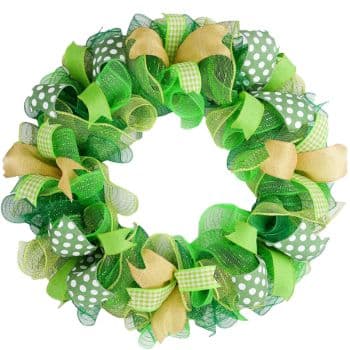 A decorative wreath featuring a mix of green ribbons and patterns, including polka dots and gingham. Accents of gold mesh add texture and contrast, creating a vibrant and festive appearance.