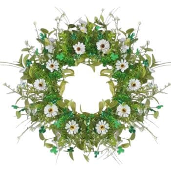 A wreath decorated with white daisies, green clovers, and various green leaves, arranged in a circular pattern. The center is empty, highlighting the floral design surrounding it.