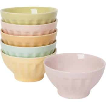 A stack of five ceramic bowls in pastel colors—green, yellow, blue, orange, and pink. Next to the stack, there is an additional pink bowl on its own. All bowls have a subtle ridged texture.