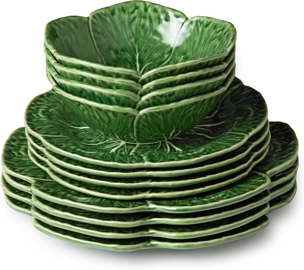 A stack of green ceramic dishes and bowls shaped and textured like cabbage leaves, arranged neatly in a pile, adds a fresh touch of spring kitchen decor.