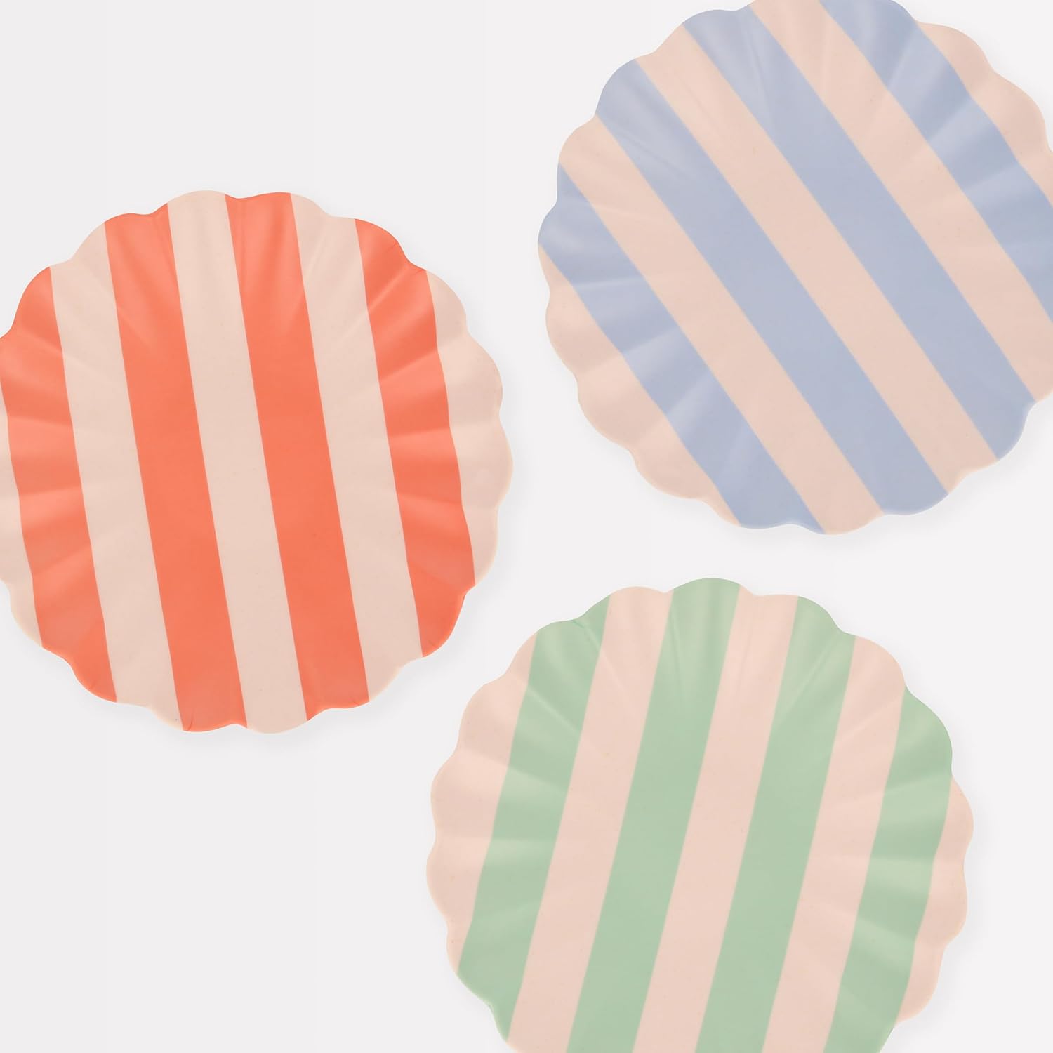 Three scalloped-edge plates with wide stripes—red and cream, blue and cream, and green and cream—are arranged against a plain white background, perfect for adding a fresh touch to your spring kitchen decor.