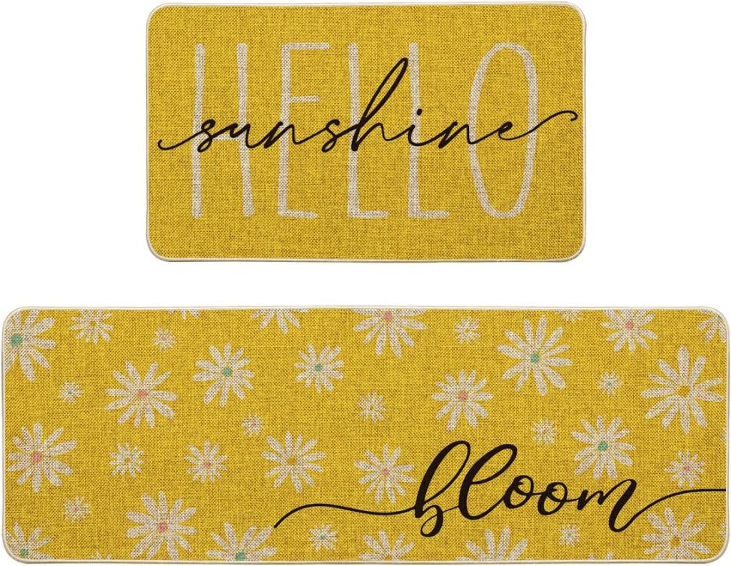 Two yellow rectangular doormats—one with "HELLO sunshine" in black script, the other adorned with white daisies and "bloom"—bring cheerful spring kitchen decor to your entryway.