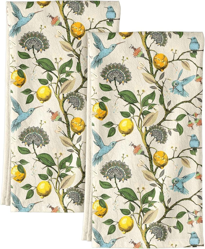 Two folded cloth napkins with a botanical pattern featuring lemons, green leaves, flowers, and blue birds on a cream-colored background—perfect for brightening up your spring kitchen decor.