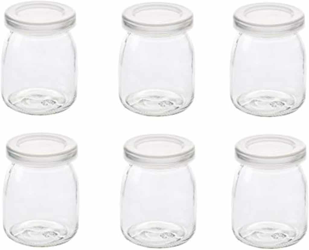 Six empty, clear glass jars with white lids are arranged in two rows of three against a white background, ready to be transformed into my favorite summer crafts.