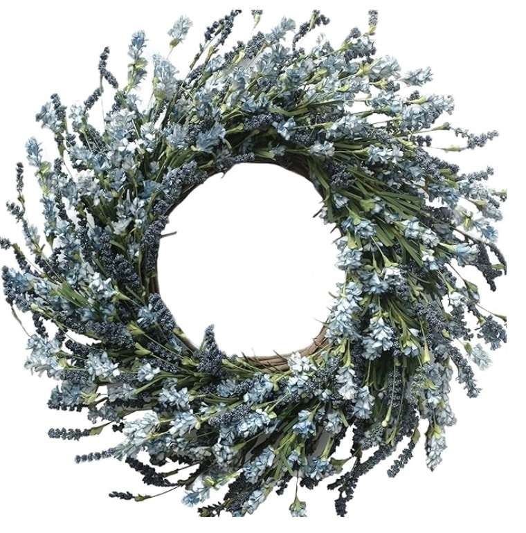 A circular wreath made of artificial blue and lavender flowers with green leaves, arranged densely on a vine base, set against a white background—perfect for those seeking colorful summer wreaths.