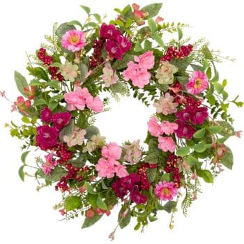 A circular floral wreath featuring pink, magenta, and red flowers with green leaves and small red berries, arranged in a lush, vibrant pattern.