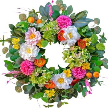 A colorful floral wreath made of green leaves, white, pink, and yellow flowers, with small orange berries arranged in a circular pattern on a white background.