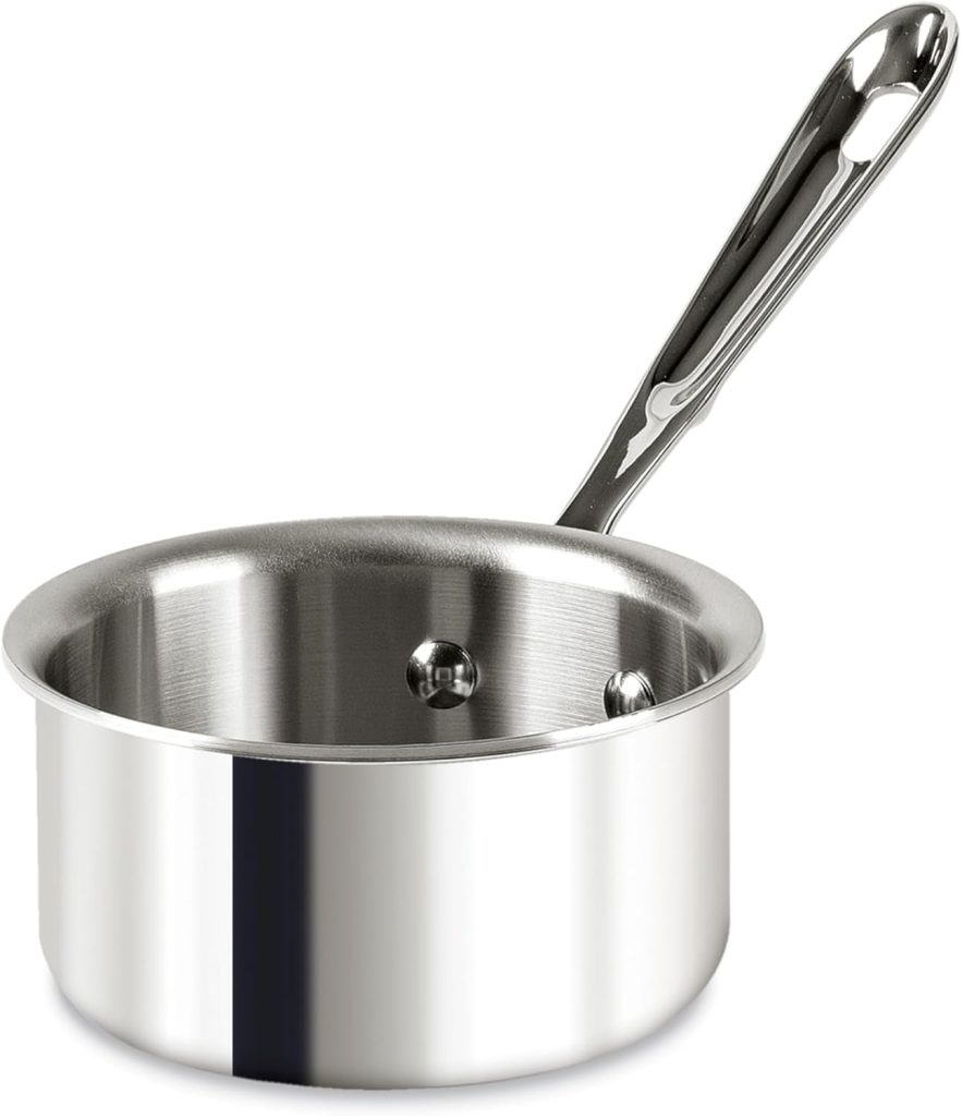 A shiny stainless steel saucepan with a long, sturdy handle is shown against a white background—perfect for learning how to make a tender, juicy steak. The pan has a smooth, reflective surface and a flat base.