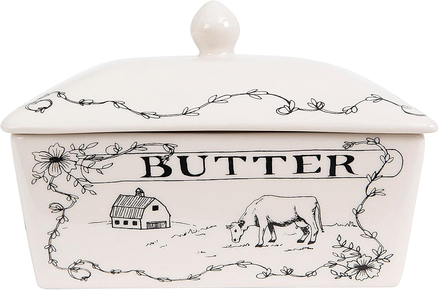 A ceramic butter dish with a lid, decorated with floral designs and a black line drawing of a cow and barn—a charming addition to any kitchen, especially for those who love learning how to make a tender juicy steak.