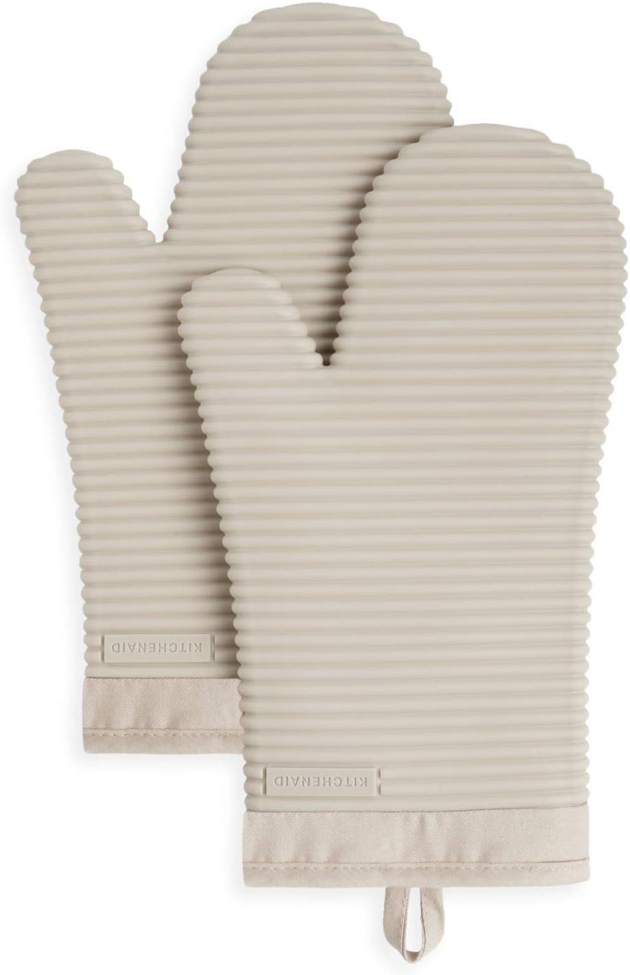 A pair of beige, ribbed silicone oven mitts with thumb sections—ideal for handling hot pans when learning how to make a tender juicy steak—featuring a fabric hanging loop and a "KITCHENAID" label on the wrist.