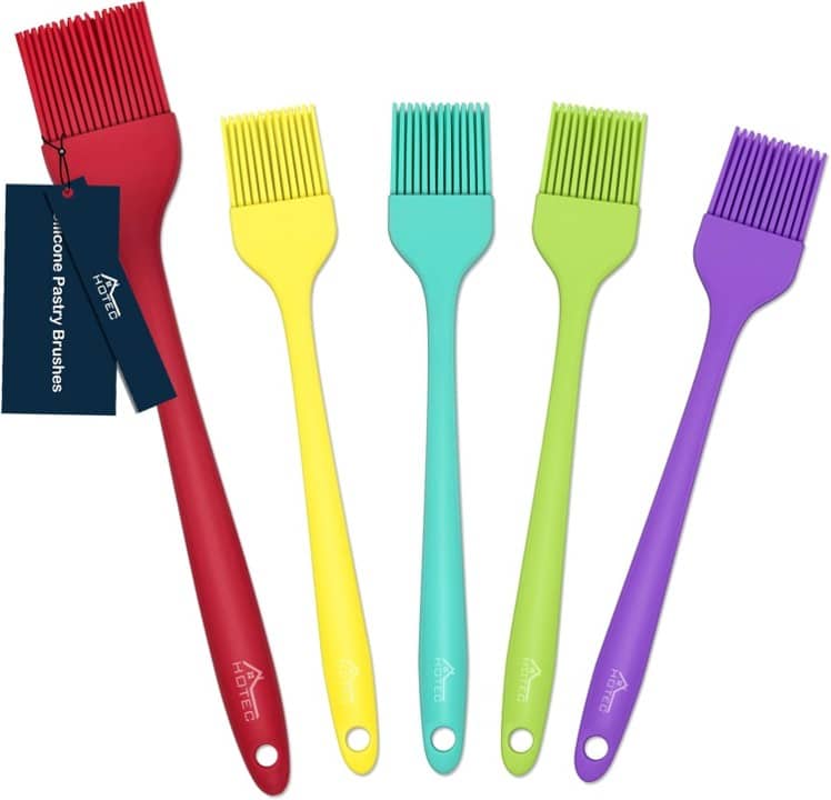 Five colorful silicone pastry brushes in red, yellow, teal, green, and purple are arranged side by side. Perfect for learning how to make a tender juicy steak, each brush has long handles and flexible bristles. The red brush features a tag.