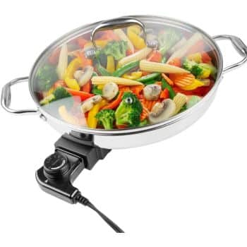A stainless steel electric skillet with a glass lid, filled with colorful vegetables like broccoli, mushrooms, carrots, baby corn, and bell peppers—one of my favorite easy dinner ideas. The skillet is plugged in and features a temperature control knob.