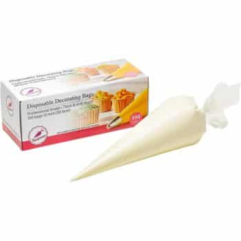 A box labeled "Disposable Decorating Bags" sits behind a filled pastry bag, perfect for trying my favorite chocolate recipes. The box displays decorated cupcakes, piping tips, and notes it's professional grade with 100 count, 12-inch size bags.