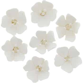 Seven white, five-petaled artificial flowers with small pearl-like beads at their centers, arranged on a plain white background, reminiscent of my favorite floral desserts.