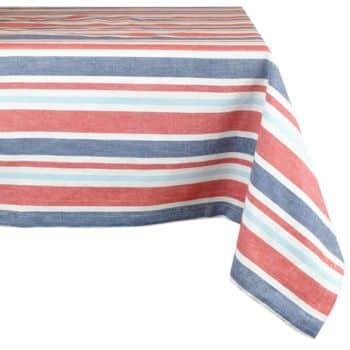 A table covered with a rectangular cloth featuring horizontal stripes in red, white, blue, and light blue. The tablecloth hangs over the edge, with the stripes running parallel to the tabletop.