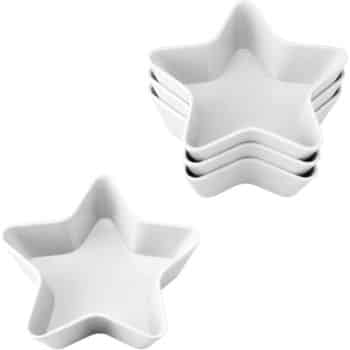 Five white, star-shaped ceramic dishes are stacked together, with one additional dish placed separately in front.